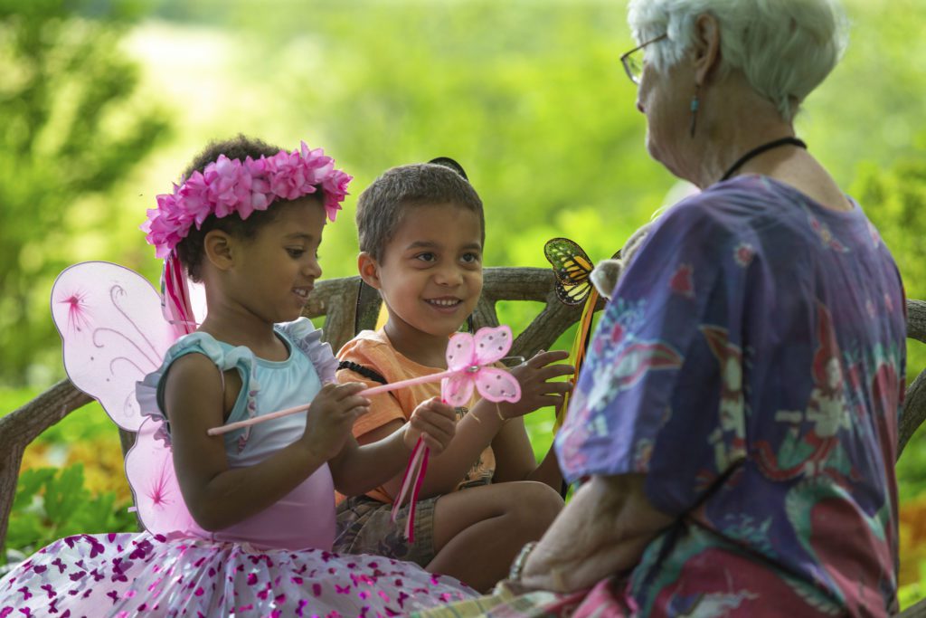 Children dressed as fairies playing with an older woman